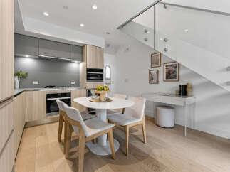 Experience modern living in this bright and airy space, featuring a sleek kitchen with integrated appliances and ample cabinet storage.