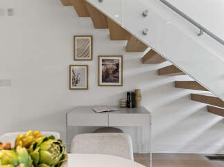 Experience modern living with this stunning staircase featuring floating wooden treads and a sleek glass railing.