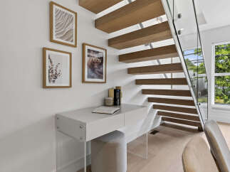 Discover modern living with this stunning staircase featuring floating wooden treads and a sleek glass railing.