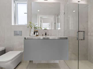 Experience modern luxury in this stunning bathroom featuring a sleek, wall-mounted vanity with a minimalist design.