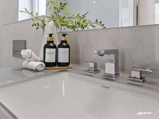 Experience modern luxury in this bathroom, featuring a sleek Duravit sink and contemporary chrome faucets.