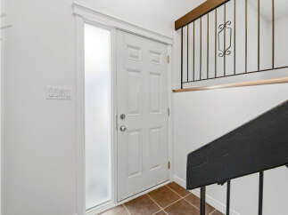 Step into a welcoming entryway featuring a bright white door with a frosted glass sidelight, perfect for natural light.