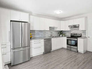 Discover this modern kitchen featuring sleek white cabinetry and stainless steel appliances, including a French door refrigerator and a smooth-top range.