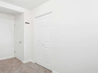 Step into a bright and airy hallway featuring two white paneled doors, perfect for maximizing space and light.