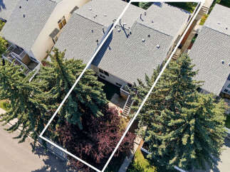 Discover this charming property from an aerial perspective, showcasing its prime location nestled amongst mature trees.