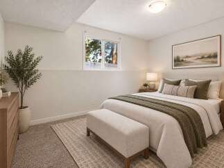 Discover comfort and style in this beautifully staged bedroom, featuring a plush bed adorned with cozy linens and accent pillows.