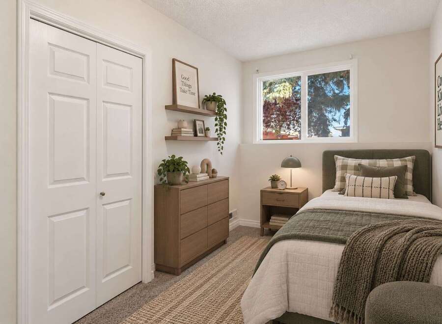 Discover this charming bedroom featuring a comfortable twin bed adorned with plush pillows and a cozy green throw blanket.