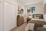 Discover this charming bedroom featuring a comfortable twin bed adorned with plush pillows and a cozy green throw blanket.