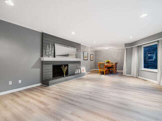 Step into this beautifully renovated living and dining area, featuring a modern gray fireplace as the focal point.