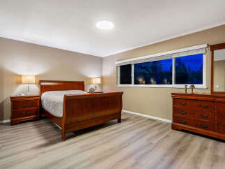 Experience tranquility in this beautifully appointed bedroom, featuring a classic wooden sleigh bed and matching nightstands.
