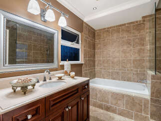 This luxurious bathroom features a spacious vanity with a marble countertop and a large, ornate mirror.