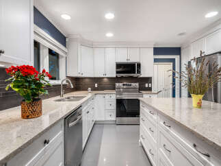 This stunning kitchen boasts sleek white cabinetry and a modern aesthetic, perfect for any home chef.