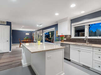 Experience modern living in this beautifully updated kitchen, featuring a spacious island with granite countertops and ample seating.