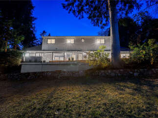 This stunning home features a spacious deck perfect for entertaining, overlooking a beautifully landscaped yard.