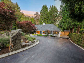Nestled amidst lush greenery, this charming home offers a serene retreat with its picturesque landscaping and mature trees.