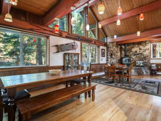 Experience rustic charm in this spacious dining area, featuring a large wooden table and bench perfect for family gatherings.