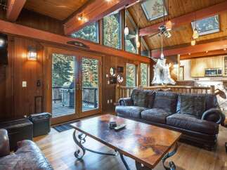 Experience rustic charm in this mountain lodge living room, featuring a spacious leather sofa and a unique copper coffee table.