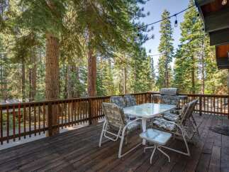 Enjoy outdoor living at its finest on this spacious deck, perfect for entertaining or relaxing amidst a serene forest setting.