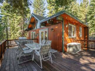 Enjoy outdoor living on this spacious wooden deck, complete with a gas grill and a dining set perfect for al fresco meals.