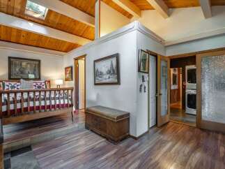 Experience rustic charm in this unique bedroom featuring a raised platform bed with a cozy quilt and a skylight for natural illumination.