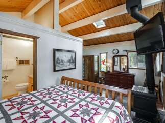 Experience rustic charm in this cozy bedroom featuring a comfortable bed with a star-patterned quilt.
