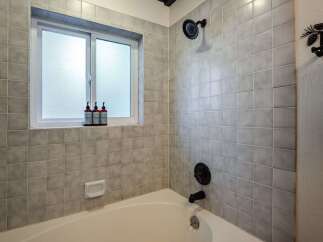This bathroom features a classic tiled shower and tub combination, perfect for a relaxing soak.