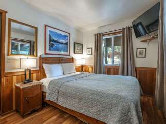 Experience rustic charm in this cozy bedroom, featuring a comfortable queen-size bed adorned with a textured quilt.