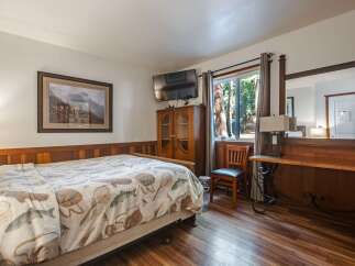 Experience rustic charm in this cozy bedroom featuring a comfortable bed adorned with a unique fish-themed comforter.