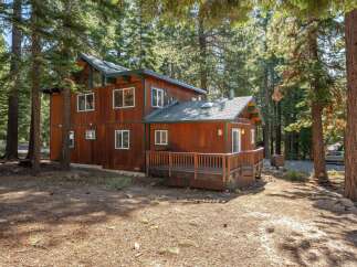 Nestled amidst tall pine trees, this charming wooden cabin offers a serene retreat.