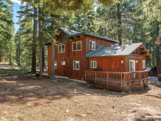Nestled amidst towering pine trees, this charming wooden cabin offers a serene retreat.