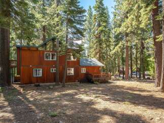 Nestled among tall pine trees, this charming wooden home offers a serene retreat.