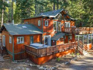 Nestled amidst towering pine trees, this charming wooden cabin offers a serene mountain retreat.