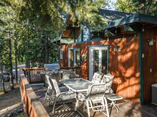 Enjoy outdoor living on this spacious wooden deck, complete with a gas grill and a dining set perfect for al fresco meals.