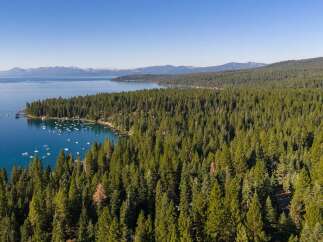 Experience the ultimate lakeside lifestyle with this stunning aerial view of a serene bay dotted with numerous boats.