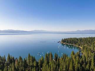 Experience the ultimate lakeside lifestyle with this stunning aerial view of a serene bay dotted with numerous boats.