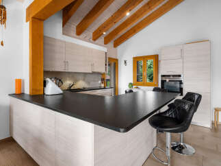 Experience modern living in this stunning kitchen featuring a sleek black countertop island with comfortable bar seating.