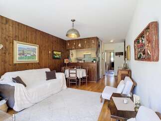 Experience cozy living in this charming home featuring a warm wood-paneled living area, perfect for relaxation.