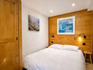 Experience cozy mountain living in this charming bedroom, featuring a comfortable queen-sized bed with crisp white linens.