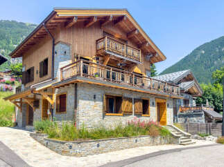Experience luxury mountain living in this stunning chalet, featuring a harmonious blend of natural stone and warm wood finishes.