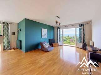 Experience breathtaking panoramic views from this spacious living area, featuring a striking teal accent wall and large double doors opening to the outdoors.