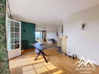 Discover this spacious living area featuring a modern dining table and a charming fireplace, perfect for cozy evenings.
