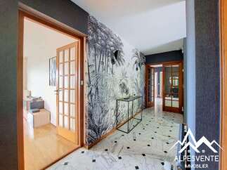 Step into a grand entryway featuring a striking botanical wallpaper and elegant marble flooring.