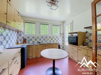 Discover this charming kitchen featuring classic blue and white patterned tiles, complemented by light wood cabinetry and a functional layout.