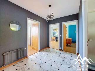 Step into this inviting hallway featuring a striking dark gray accent wall adorned with a circular mirror.