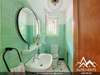 Step into this charming bathroom featuring a stylish vanity with a round mirror and a convenient towel rack.