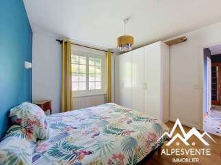 Discover this charming bedroom featuring a vibrant floral duvet and a striking blue accent wall, creating a lively and inviting atmosphere.
