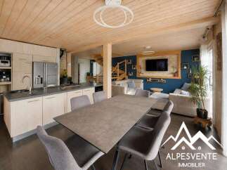 Discover this modern open-concept living space featuring a sleek kitchen with stainless steel appliances and ample counter space, flowing seamlessly into a cozy dining area.