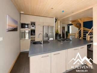 Discover this modern kitchen featuring a sleek island with a built-in gas stovetop and a deep sink, perfect for culinary enthusiasts.