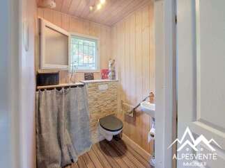 Discover this charming bathroom featuring a rustic wooden interior and a stone-accented wall.