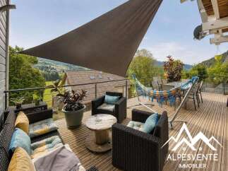 Enjoy breathtaking mountain views from this stunning balcony, complete with a shaded seating area and a vibrant hammock for ultimate relaxation.